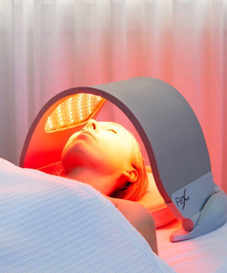 Client lying under a Dermalux Flex LED light therapy panel