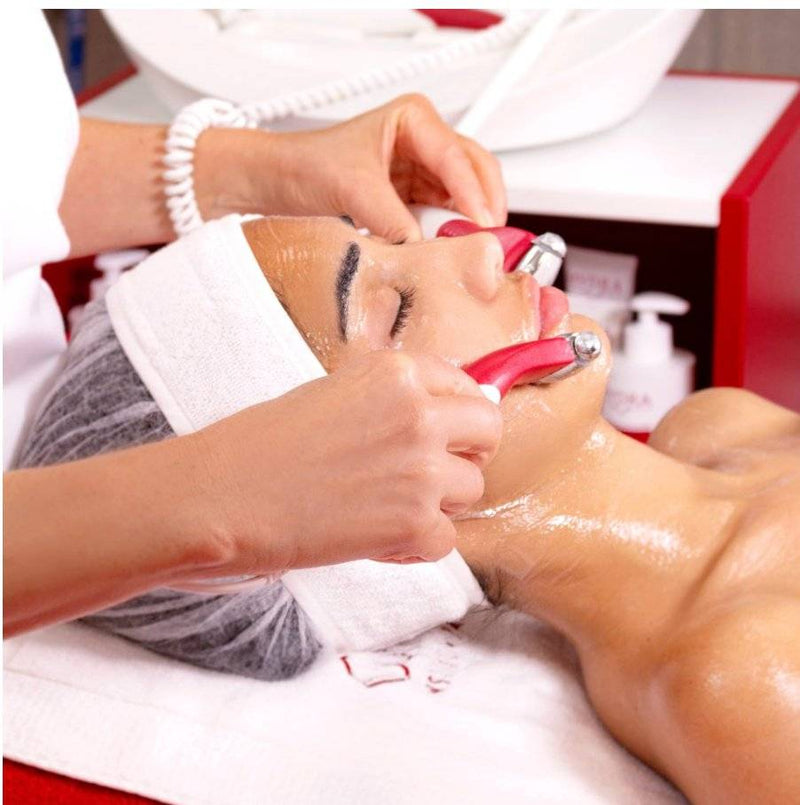 Therapist using Guinot Hydradermie rollers on a client's face